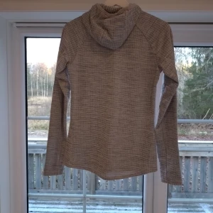 Grå långärmad hoodie - Säljer en stilren grå långärmad hoodie i mycket bra skick. Perfekt för kyliga dagar med sin mjuka och bekväma passform. Den har en diskret mönstring och en praktisk huva. Passar både till vardags och för en avslappnad stil.