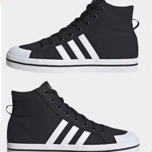 Säljer ett par snygga svarta sneakers från Adidas i mycket bra skick. De har klassiska vita ränder på sidan och en vit sula. Perfekta för både vardag och fest! Skorna har snörning och är i storlek 40 2/3