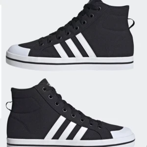 Svarta sneakers från Adidas - Säljer ett par snygga svarta sneakers från Adidas i mycket bra skick. De har klassiska vita ränder på sidan och en vit sula. Perfekta för både vardag och fest! Skorna har snörning och är i storlek 40 2/3