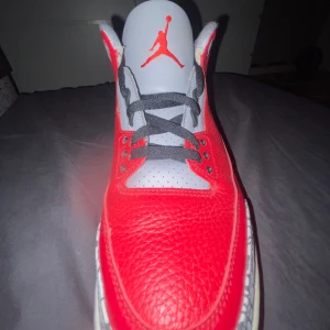 Nike Air Jordan 4 Retro - Säljer ett par Nike Air Jordan 4 Retro i rött och svart. Skorna har den klassiska Jumpman-loggan och är i mycket bra skick. Perfekta för både samlare och sneakerheads. De har en snygg design med grå detaljer och är tillverkade i skinn.