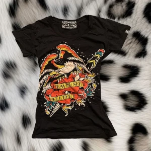 Y2k t-shirt med coolt tryck❤️ - Super fin t-shirt ifrån märket liqourbrand med coolt tryck på framsidan❤️den är storlek L men sitter ändå tight skulle snarare säja den sitter som en S:)