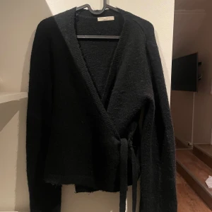 Svart omlottkofta från Gina Tricot - Mysig svart omlottkofta från Gina Tricot i storlek L och är helt slutsåld på hemsidan! skriv för fler bilder 💕