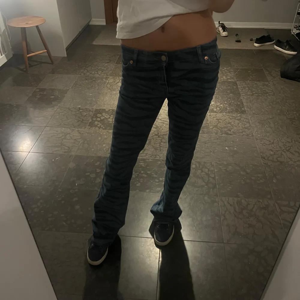 Säljer ett par coola blå jeans med zebra-mönster. De är lågmidjade och har en bootcut-stil! Jättesnygga!! 🦓💙. Jeans & Byxor.