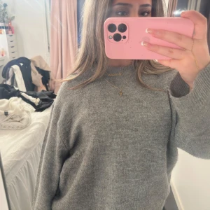 Grå stickad tröja XS - Mysig grå stickad tröja i storlek XS men kan tänka mig att den passar upp till M, från lager 157. Perfekt för höst och vinter med långa ärmar och ribbade muddar. Enkel och stilren design som passar till allt. 🧶