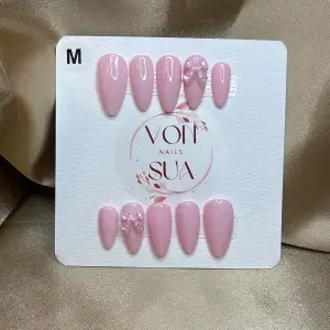 Säljer ett set med eleganta rosa lösnaglar i storlek M. Naglarna har en glansig finish och några är dekorerade med fina stenar för extra bling. Perfekta för en chic look! 💅✨