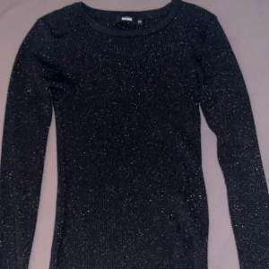 Svart glittrig tröja från Bik Bok - Säljer en snygg svart glittrig tröja från Bik Bok i storlek XS. Använd ett par gånger men inga skador alls!!