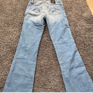 Blå jeans med broderad detalj - Säljer ett par snygga blå jeans med broderade detaljer på bakfickorna. De har en bootcut. Inte mina bilder, kontakta för egna bilder och mått!! Köpte byxorna på Vinted men dom var inte som jag tänkte därav säljer jag💕💕💕 pris kan diskuteras. Storlek xxs/xs