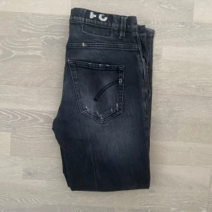 Dondup Jeans - Säljer dessa svarta Dondup jeans i mycket bra skick med en cool, sliten look. Endast använda ett fåtal gånger. Längd: 93cm, Bredd: 40cm. Slim fit. Nypris 4000kr. Skriv vid frågor och funderingar!