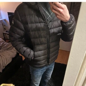 Svart dunjacka från Colmar - Säljer en snygg svart dunjacka från Colmar i mycket bra skick. Jackan är perfekt för kyliga dagar med sitt quiltade mönster och dragkedja framtill. Den har en normal passform och är långärmad, vilket gör den idealisk för både höst och vinter. Perfekt för dig som vill hålla stilen samtidigt som du håller värmen! Användes enbart  några gånger förra året.  Fint skick och inga skador.  Alla lappar följer med.  Passar storlek M/L Skriv vid frågor. 