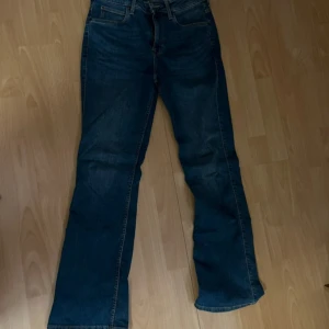 Blå jeans från Lee - Säljer ett par snygga blå jeans från Lee i bra skick. De har en klassisk bootcut-stil och är perfekta för både vardag och fest. Jeansen är midwaist och väldigt bekväma!