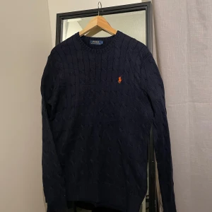 Ralph Lauren stickad tröja - Trendig marinblå stickad tröja från Ralph Lauren i storlek S, väldigt fint skick! Inköpt för 2400kr, säljer den för 1099kr nu.