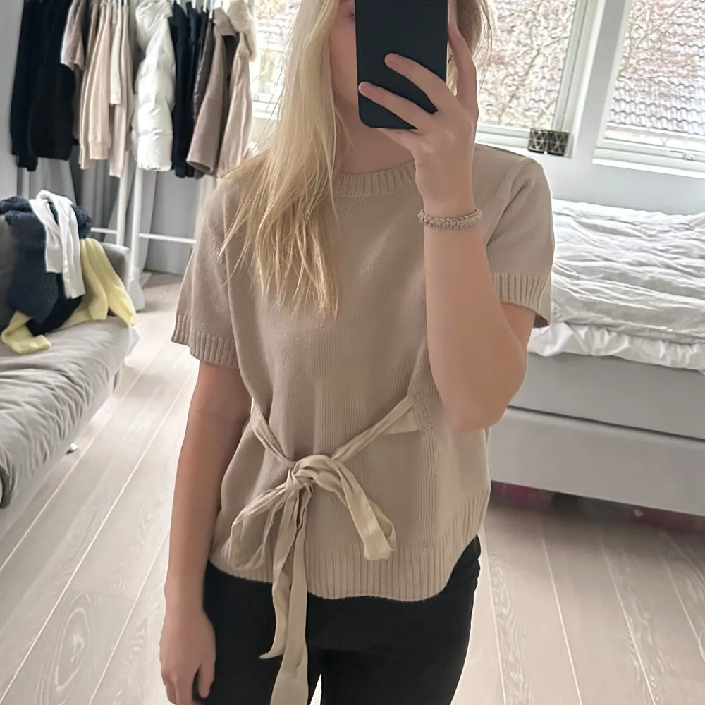 Säljer en superfin beige tröja från Zara i storlek L. Den är kortärmad och har en snygg knytning i midjan som ger en fin siluett. Perfekt för både vardag och lite finare tillfällen. Materialet känns mjukt och skönt mot huden. Passar perfekt till höst och vår! Liten i storlek, passar xs-m även om det är L som står på lappen. Tröjor & Koftor.