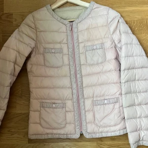 Ljusrosa moncler liknande jacka - Säljer en superfin ljusrosa moncler liknande jacka med dragkedja fram. Den har två praktiska fickor med knappar på framsidan. Perfekt för vår och höst när det är lite kyligt ute. Jackan är i bra skick och har en normal passform.