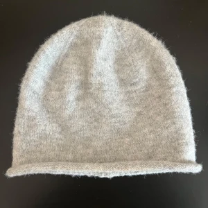Grå stickad mössa  - Säljer en supermysig grå stickad mössa från Natura. Perfekt nu i vinter och passar till allt. Mössan är i mycket bra skick och i kashmirblandning❤️