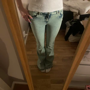 Bootcut jeans från Monki - Säljer ett par turkos/blågröna bootcut jeans från Monki i bra skick. De är lågmidjade och har en snygg vintage look. Perfekta för både vardag och fest! 🦋Långa på mig som är 176!