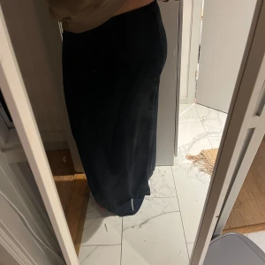 Mörkblå långkjol - Säljer en elegant mörkblå långkjol i nytt skick. Perfekt för både vardag och festliga tillfällen. Kjolen har en enkel och stilren design som gör den lätt att matcha med olika toppar och accessoarer. Passar perfekt för vår och höst!