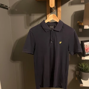 Mörkblå pikétröja från Lyle & Scott - Säljer en snygg mörkblå pikétröja från Lyle & Scott i väldigt bra skick. Säljs då den har blivit för liten. Pris är diskuterbart! Hör av dig om du har några frågor. 