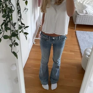 Lågmidjade jeans från True Religion - Säljer ett par snygga lågmidjade jeans från True Religion i ljusblå denim. Perfekta för både vardag och fest💞