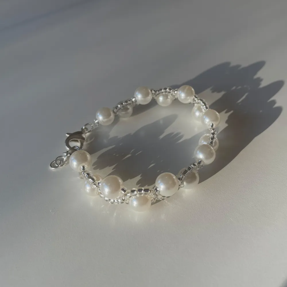 Pearl bracelet with glass pearls and big white pearls. Available in gold and silver 🐩. Accessoarer.