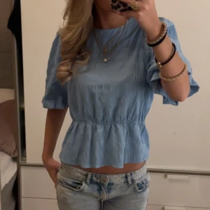 Ljusblå blus med volangdetaljer - super söt blus 