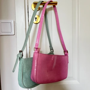 green and pink bags  - Two small shoulder bags. The geen bag is made from a sage green corduroy fabric, where as the pink bag is made to imitate a snake print. Both bags are from Cotton On. 