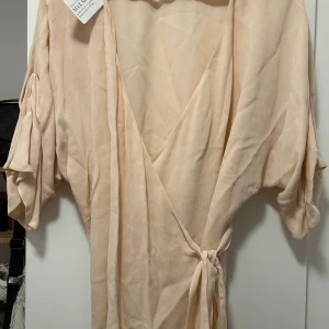 Max mara topp  - Helt ny omlott topp från max mara i ljus Rosa storlek 42 men passar allt mellan S-L då det är omlott och går knyta. Jag har S och den sitter bra på mig. Materialet är lite mesh men är inte genomskinlig. Nypris3499 säljer för 1000. Går bra att mötas. 