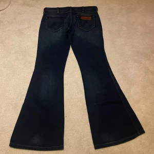 Lågmidjade jeans - Lågmidjade, bootcut/ utsvängda jeans från wrangler! Storlek 27/30 tror jag och dem är helt nya! Passade inte mig så därav säljer jag dem! Hör av dig om du har nån fråga!🩷