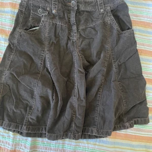 Brun manchesterkjol från Esprit - Säljer en snygg brun manchesterkjol från Esprit. Kjolen har en klassisk A-linjeform och är perfekt för höst och vinter. Den har praktiska fickor och en knappdetalj framtill. Passar perfekt till både vardag och fest!