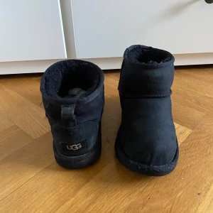 UGG boots - Säljer ett par svarta UGG boots. De är supermysiga och perfekta för vintern. Dem är Strl 35 passar också 36 perfekt! Hål vid sidan av ena skorn!