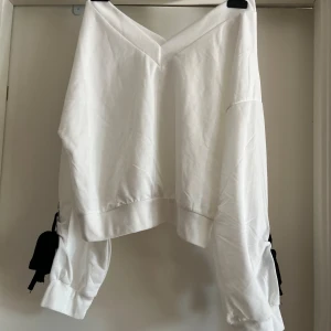 Tröja  - Vit tröja med rosetter på armarna. I väldigt bra skick 