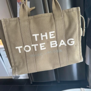 Marc Jacobs Tote Bag Medium - Väskan har ingen lång rem men det är original . Deformationerna är som på bilden. Khaki färgen.
