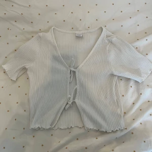 Topp - Fin vit topp från Lindex i storlek 134/140. Använd fåtal gånger! Passar att ha över ett linne eller t-shirt. Den har två band som man knyter framtill. Pris kan diskuteras! 💕 