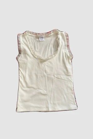 Vit topp med fina detaljer  - jag har sytt in den men det går att sprätta upp