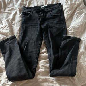 Svarta lågmidhade jeans - Svarta lågmudjade jeans, passformen är lite ”skinny” men byxorna går ut lite längst ner!