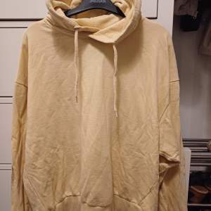 Säljer en mysig beige hoodie i herrstorlek. Den har en klassisk design med en stor huva och dragsko. Perfekt för en avslappnad stil och passar till alla tillfällen. Materialet känns mjukt och bekvämt, perfekt för kyliga dagar. Något tvättluddig