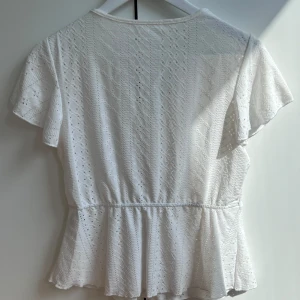 Vit topp  - Säljer då denna söta topp med fin spets detalj då inte kommer till användning. Jättefint skick använd bara två gånger!!  Skriv om du har frågor annars klicka bara på köp nu!❣️