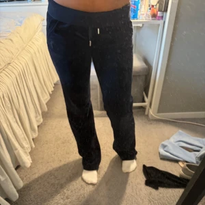 Svarta mjukisbyxor från Juicy Couture - Säljer ett par mörkblå mjukisbyxor från Juicy Couture i storlek XS. De är superbekväma med en normal passform och har snörning i midjan. Perfekta för en avslappnad dag hemma eller en snabb tur till affären.