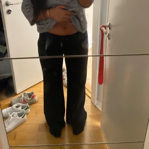 Svarta Lågmidjade kostymbycor - Ett par svarta utsvängda kostymbyxor från märket new look i fint skick! Storlek 12 men skulle säga att de är motsvarande en medium beroende av hur man vill att de sitter. Jag brukar ha S/M och tycker att de sitter bra!!