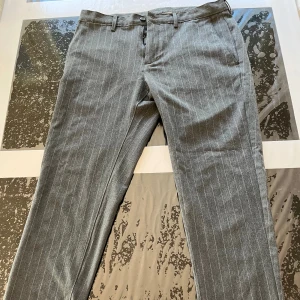 Randig kostymbyxa från Zara i ett mycket bra skick - Storlek 42, 9/10 begagnat skick, mörkgrå färg, randigt mönster, inga hål eller fläckar, mycket bra skick!