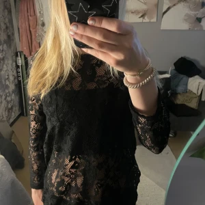Svart blus - Säljer denna super fina blusen! Knappt använd. Genomskinlig med blommönster. Strl M. Sitter bra men är väldigt lång!