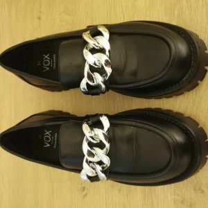 Chunky Loafers stl 38 - Chunky loafers stl 38 från VOX med en fin silverkedja.  Använda enbart 2 ggr, säljer pga det är för små för mig. Finns i Hökarängen 