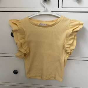 Ljus gul volang topp från zara - Säljer nu denna sjukt fina volang tröja som jag köpte på zara för ungefär två år sedan. Jag har använt den vid två tillfällen men annars har den bara legat i min garderob så den är i mycket fint skick. Jag säljer eftersom jag inte har någon användning för den men det finns inga defekter eller liknande. Storlek s men skulle säga mer xs-s💕