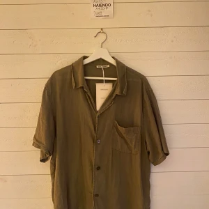 Olivgrön kortärmad skjorta från H&M - Säljer en olivgrön box shirt från Our Legacy. Nypris 2500kr & går ej att få tag på längre. Endast testad.