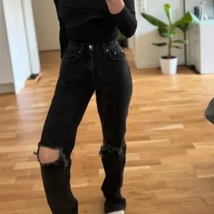 Säljer ett par svarta jeans med coola slitningar på knäna. De är högmidjade och har en straight passform som ger en avslappnad look. Perfekta för en casual outfit eller när du vill lägga till lite edge till din stil. De är i bra skick och redo för nya äventyr!