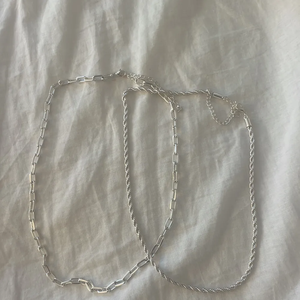 Två oanvända silver halsband. One size och kommer från New yorker. . Asusteet.