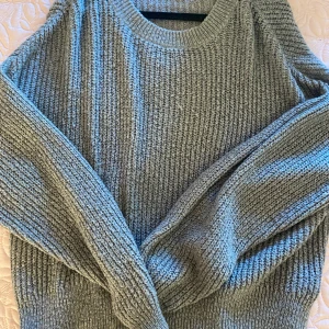 Lång stickad tröja  - Mjuk lång stickad tröja i mörk grå