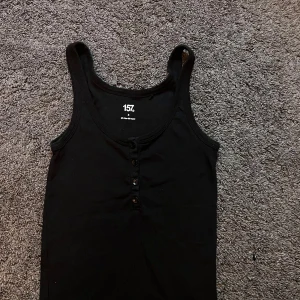 Svart linne  - Ett enkelt svart linne med knappar 