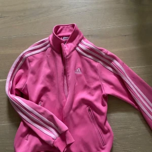 Rosa Adidas Kofta - sparsamt använd, dragkedjan är sönder men den går att stänga & det står ingen storlek men skulle gissa på XS.
