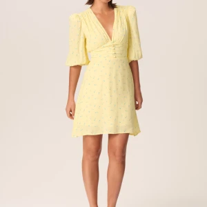 Helt ny Adoore Gul kortklänning med blommigt mönster - Ny Adoore klännig i strl 36.  Säljer en superfin gul kortklänning med ett sött blommigt mönster. Klänningen har en v-ringad omlott-design och trekvartsärmar som ger en romantisk känsla. Perfekt för sommarens alla fester eller en härlig dag på stan! 🌼