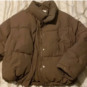 Pufferjacka - Brun puffer från Bershka, använd under en vinter så den är i bra skick, lite vit färg på ena ärmen (syns på bild) men inget som syns på håll, snörena nere på jackan har gått sönder lite (syns på bild) men funkar som dom ska, stl L, nypris 600kr